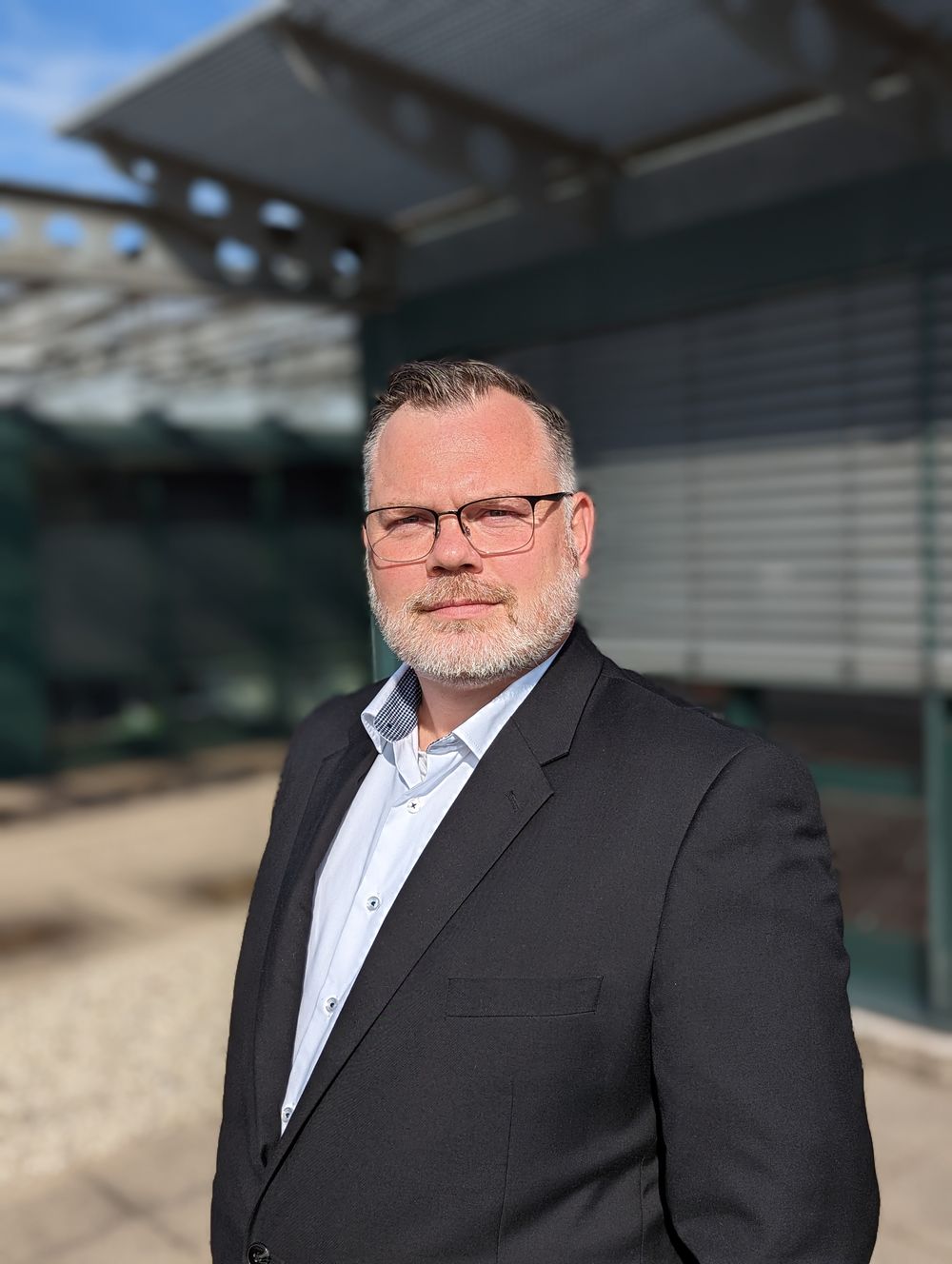 Hagen Mittag, Versicherungsmakler aus der Region Aschaffenburg und Hanau, im Anzug vor einem Bürogebäude